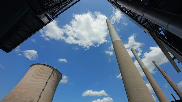 Picture of industrial smokestacks, part of a manufacturing facility.