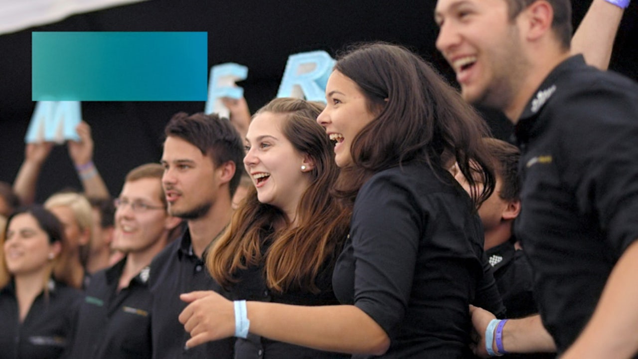 A Formula Student Germany event with a group of people gathered around a race car.