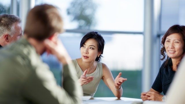Group of colleagues sitting around a table having a discussion.