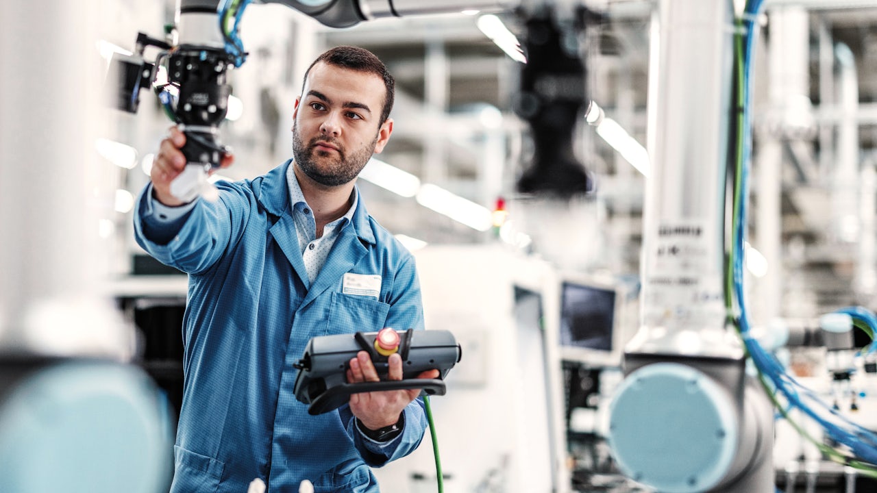 Man programming a machine in a factory.