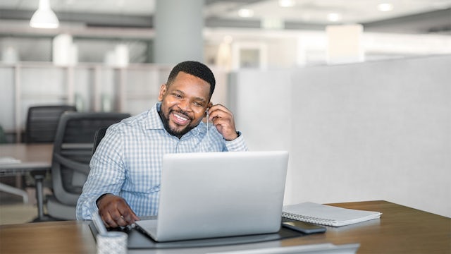 Man sitting in front of a laptop taking a video call.