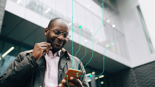 A man holding a phone walking out of an office.