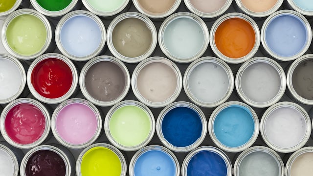 A top-down view of open paint cans showing a variety of colors.