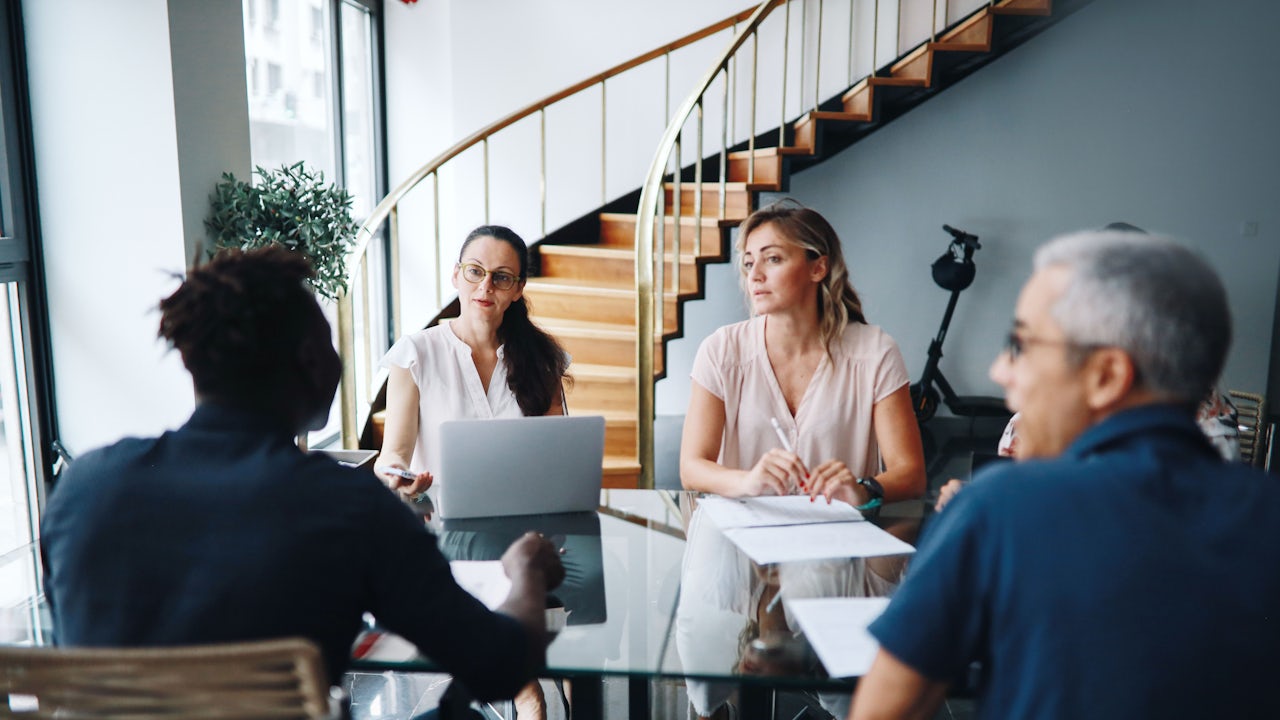 Group of colleagues sitting around a table having a discussion.