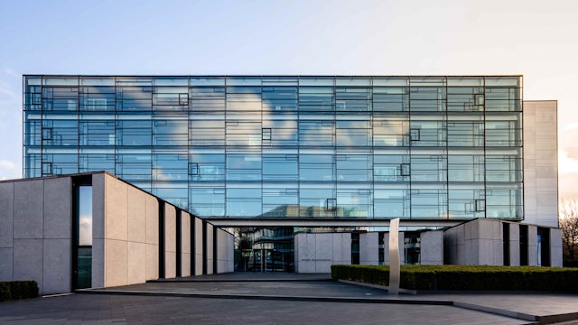 The front of a corporate building with a lot of glass panels.