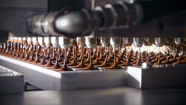 Factory machines dispensing chocolate on a factory line.