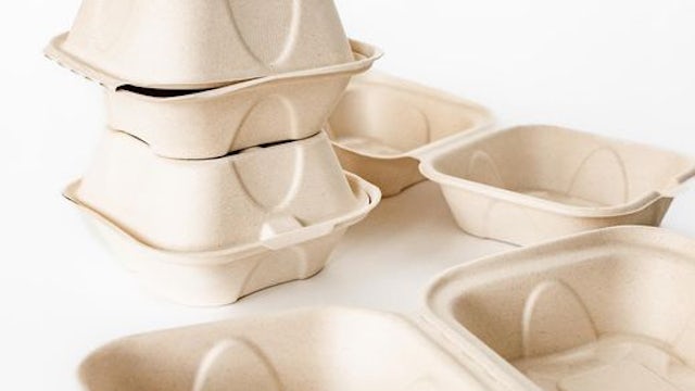 Four plant-based food containers on a white surface.