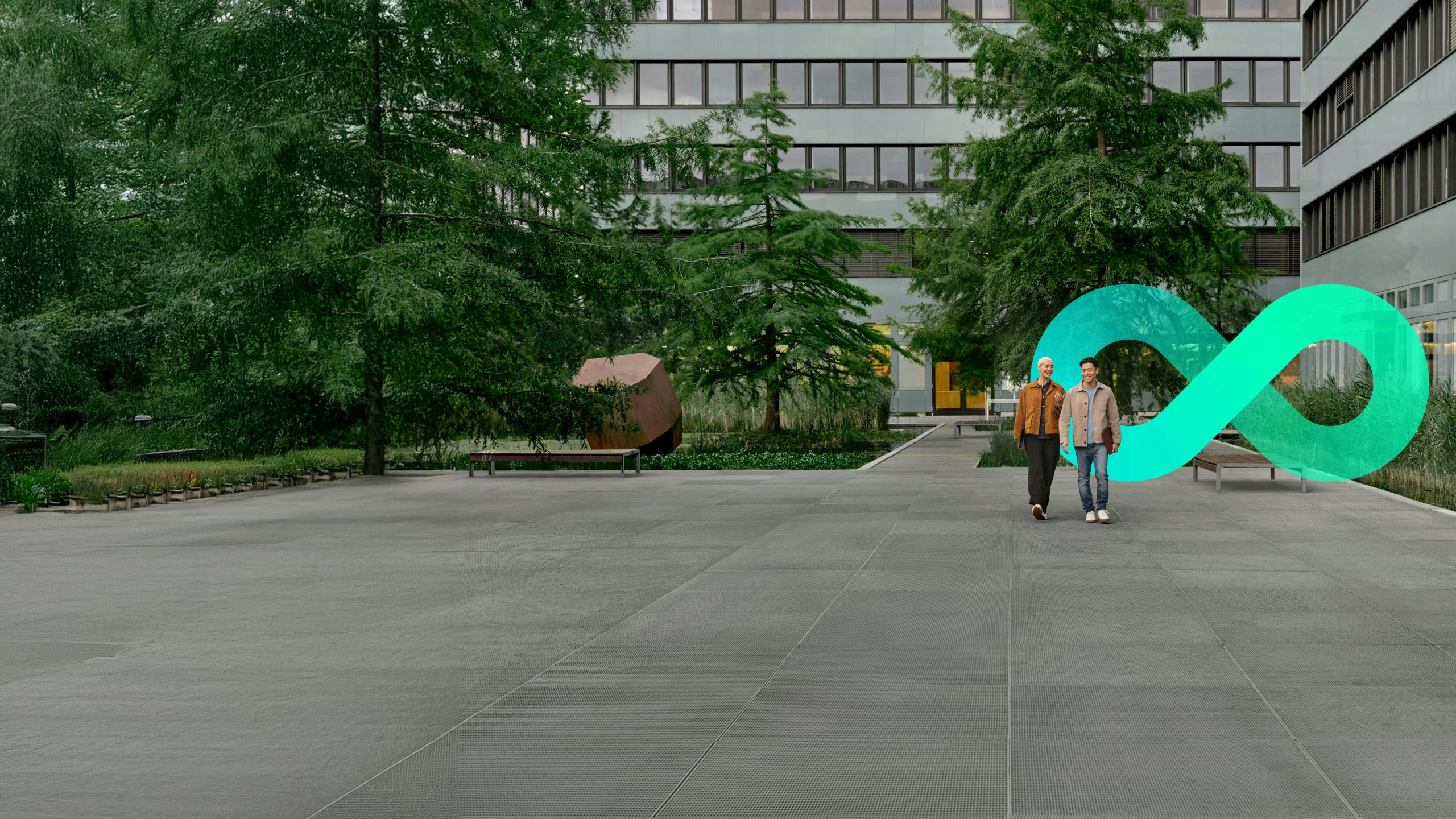 Two young people walking on a campus in front of the Siemens transformation shape.