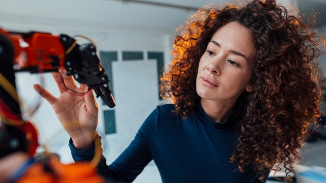 A woman working with a SIE-HM24-KV robot.