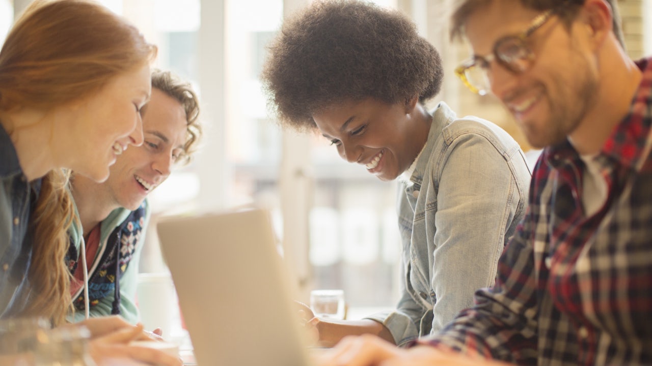 Friends sitting in a cafe, enjoying their drinks and conversation.
