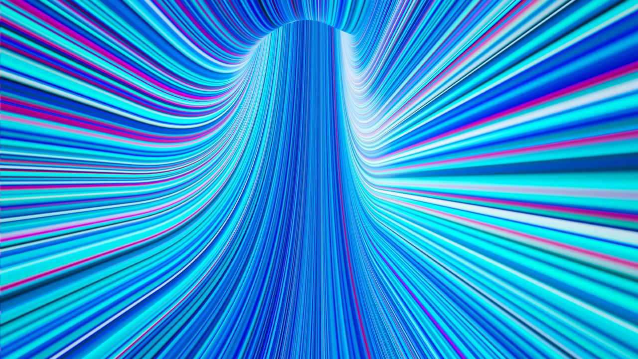 Smiling woman with curly hair wearing a yellow sweater against a pink background