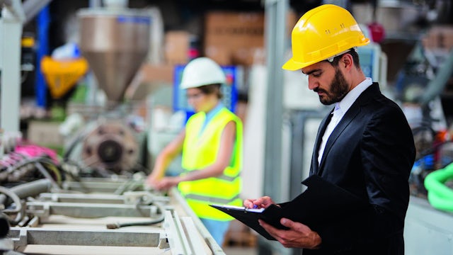 A quality inspector checks the manufacturing production line.