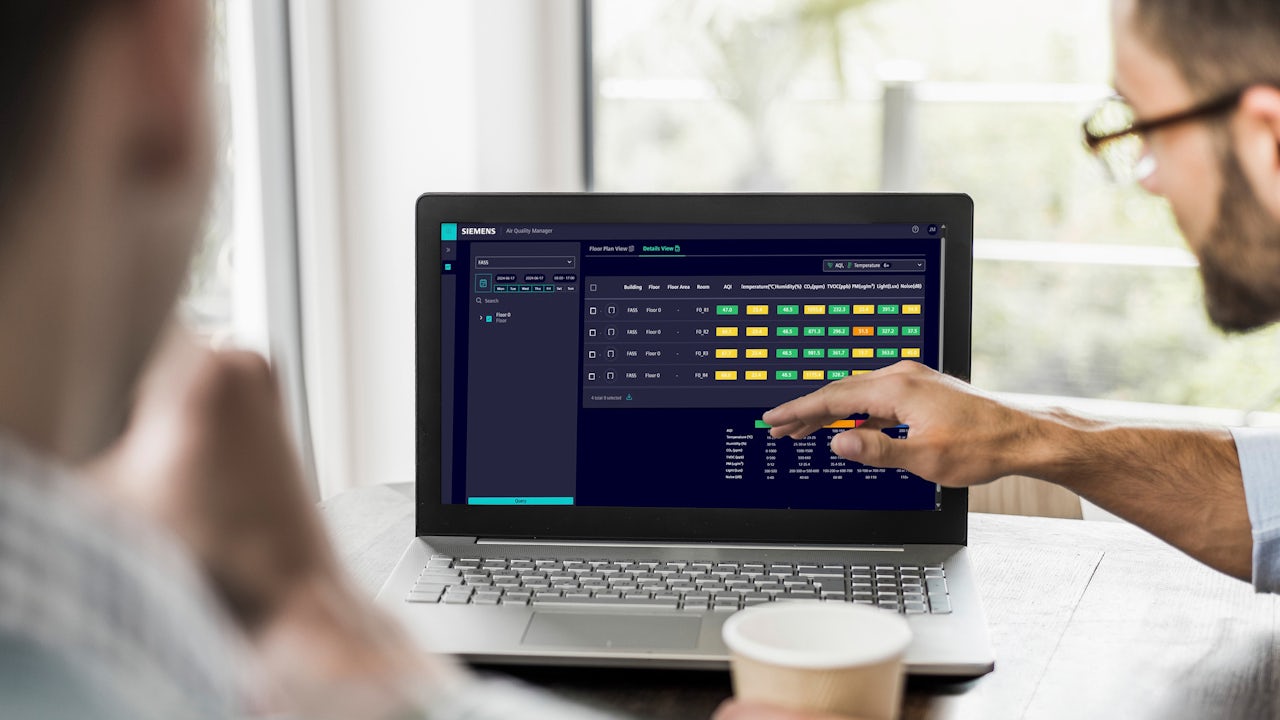 A hand holding a smartphone displays an application form on the screen against a blurred background.