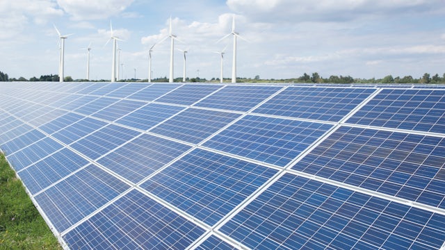 Solar panels and windmills in a field.