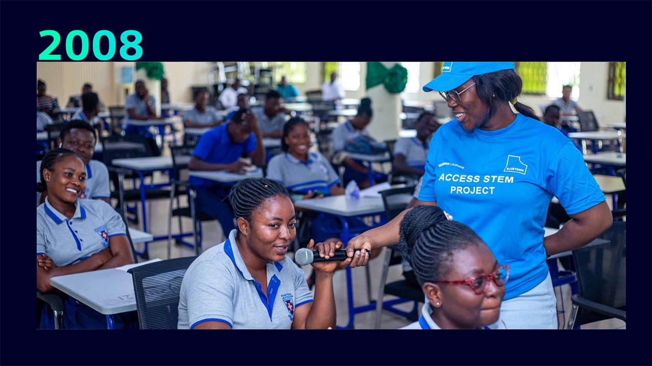 Person in wheelchair working at desk with computer and assistive technology devices