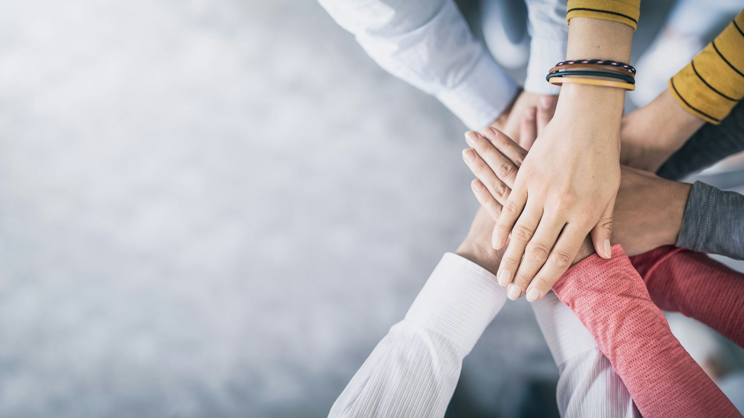 Hands stacked together signifying teamwork.