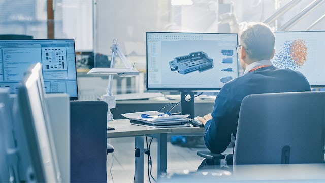 An engineer at his computer workstation uses software to create a digital twin of a machine he is designing.