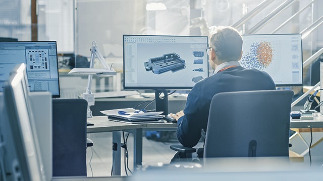 Man sitting at a computer with his back towards the camera