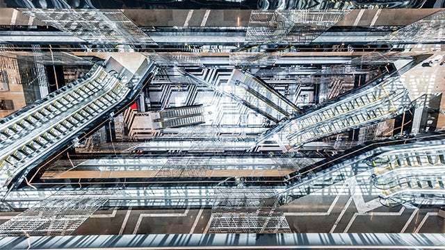 Group of activists standing outside building, one speaker addressing crowd with microphone raised
