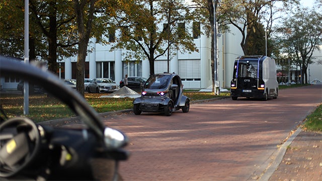 A book cover featuring a futuristic autonomous vehicle with a sleek design and a blurred background.