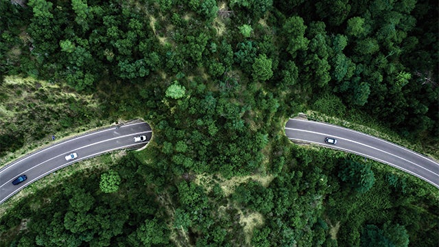 A blog post about automotive sustainability featuring a car and a factory in the background.