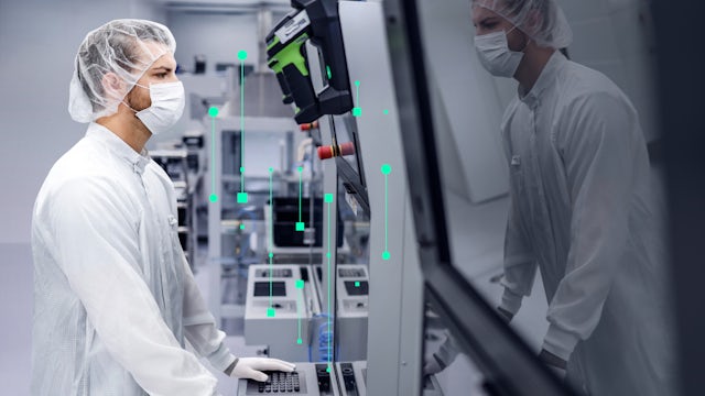 A man in a cleanroom suit and face mask operates machinery, with green data overlays suggesting advanced manufacturing or quality control.
