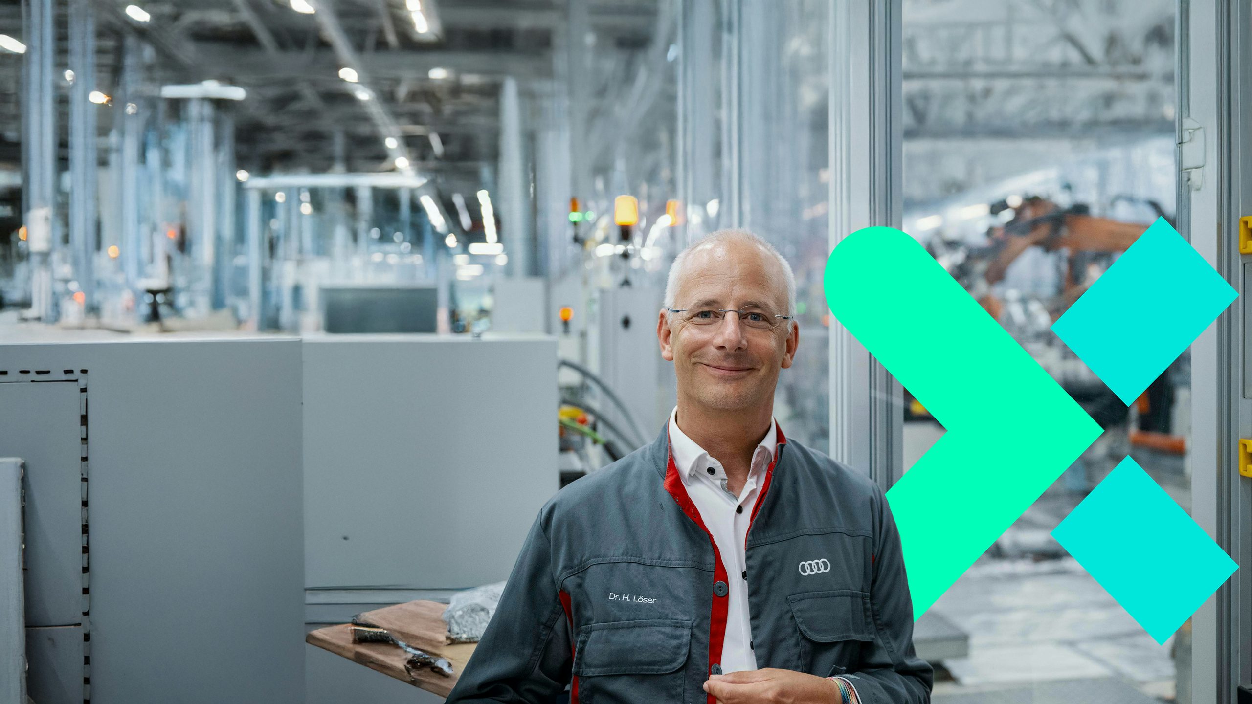 Dr. H. Löser on the factory floor, smiling for the camera.