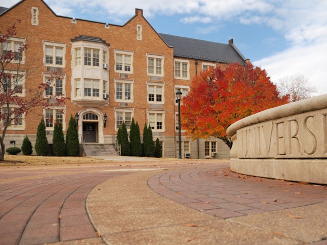 University sign and building in autumn.
