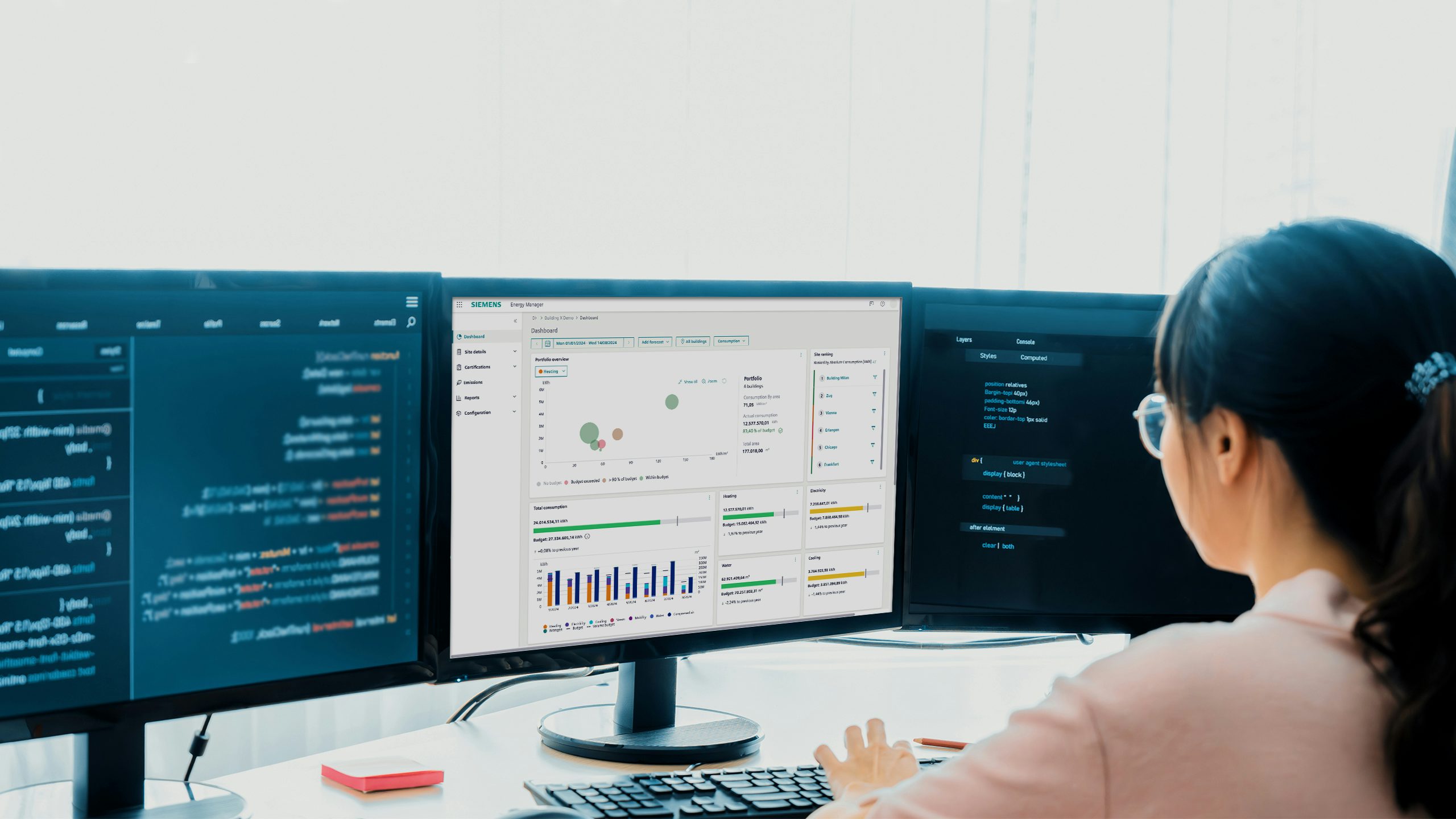 Woman working at a computer with three monitors to help build, sell and service our Building X partners.