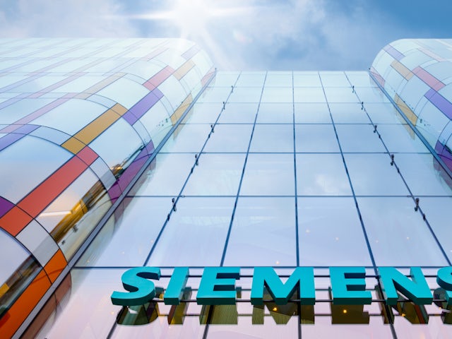 Looking up at the Siemens Real Estate Sweden group building with the sun shining.