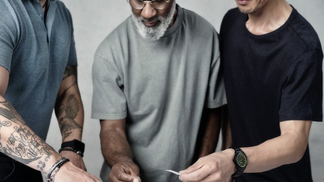 Three people arranging content on a layout prototype.