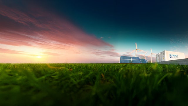 Solar panels and windmills near an energy storage container.