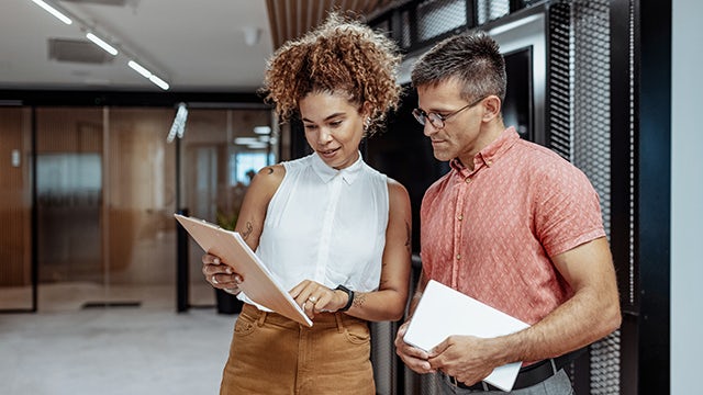 The image shows a group of people in an office setting, collaborating on a project.