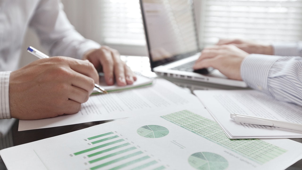 The image shows a group of people collaborating on a project in an office setting.
