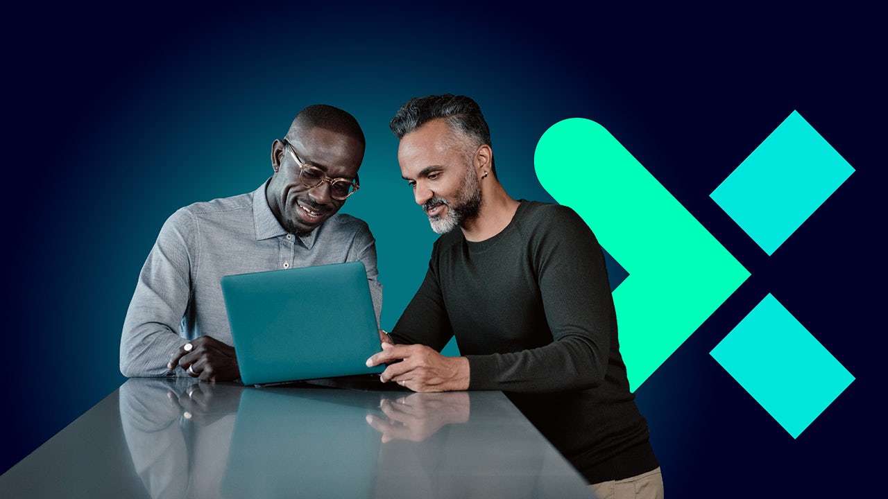 Two men discussing amongst themselves in front of a lap top.