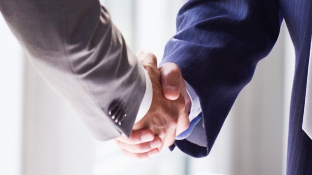 Closeup of two businesspeople shaking hands.