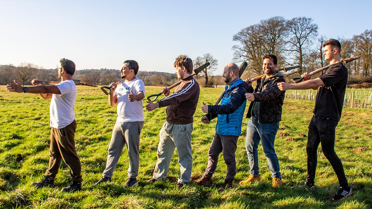 Volunteers in matching uniforms work together on a community service project outdoors.
