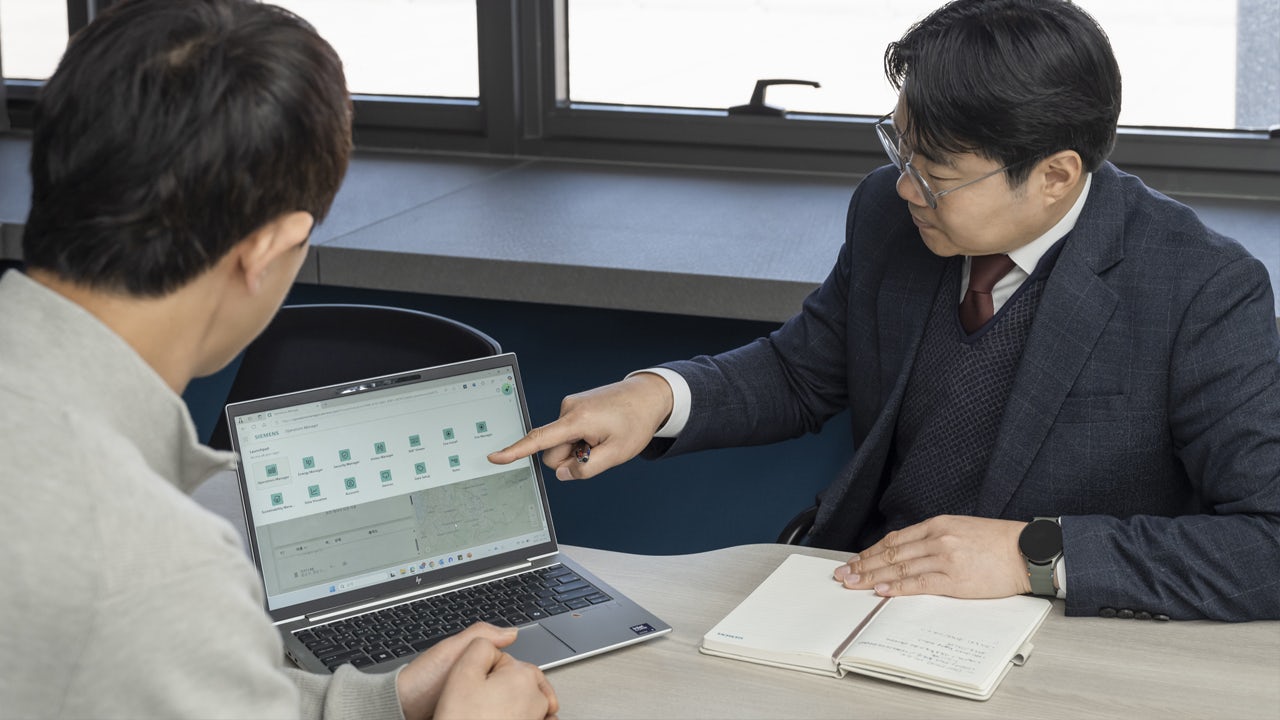 Two WONIK HOLDINGS employees look at cable box