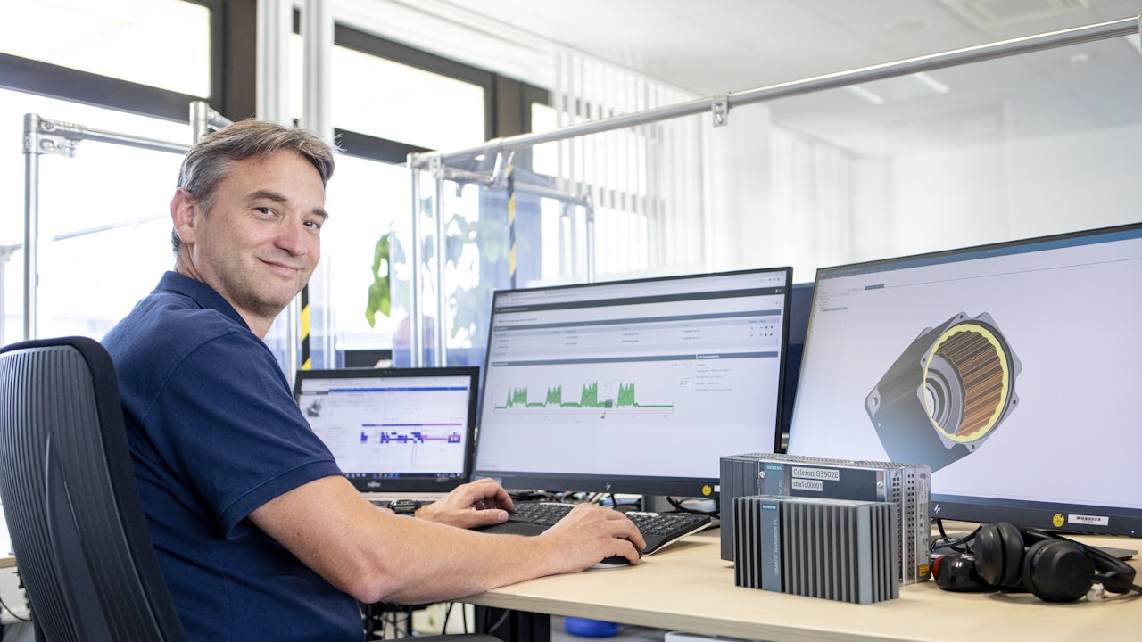 A golden retriever puppy sitting on grass, looking up with a curious expression.