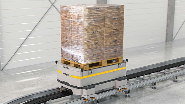 A warehouse with a large number of storage boxes and shelves, and a person standing in front of the shelves.