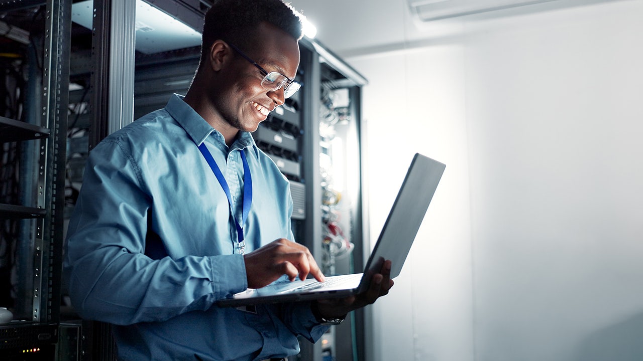 Man standing with laptop.