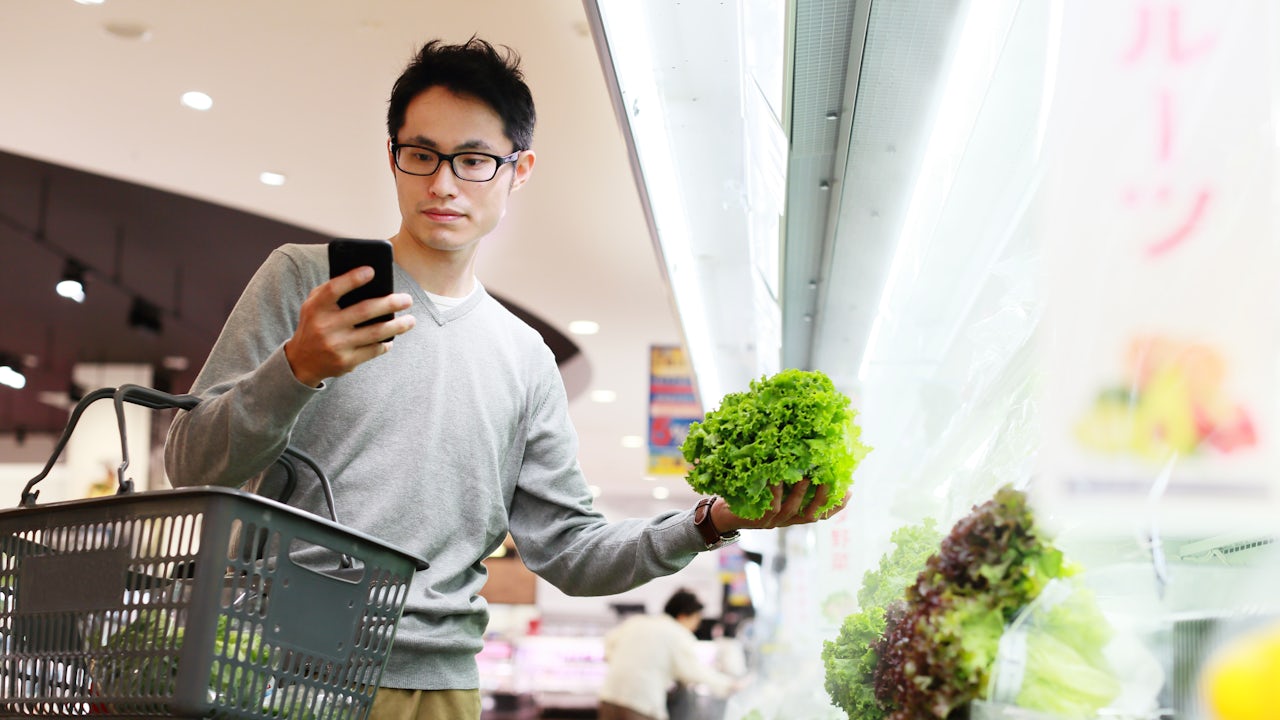 A man is purchasing food items in a supermarket.