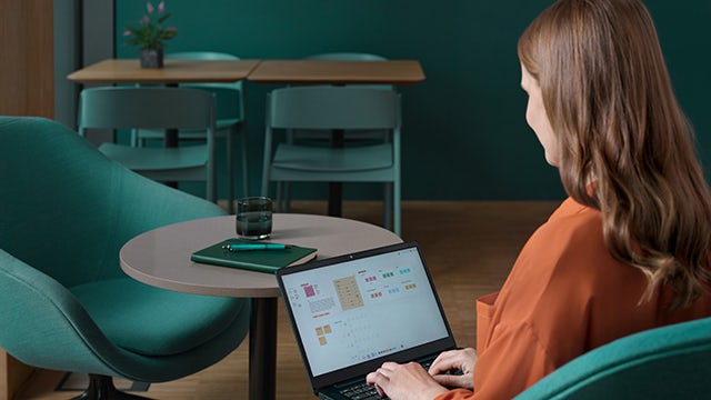 Worker in safety gear standing near industrial machine with safety display screen
