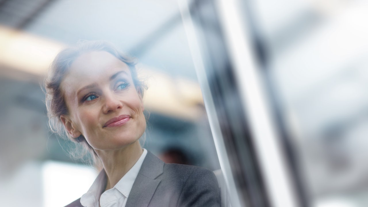 A sustainability manager looks out a building window.