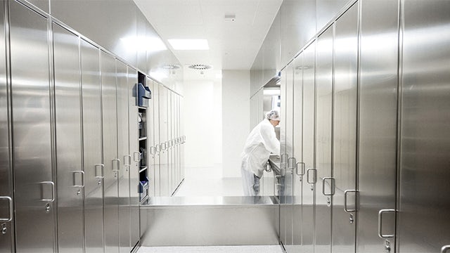 Three men looking at a diagram on a large screen.