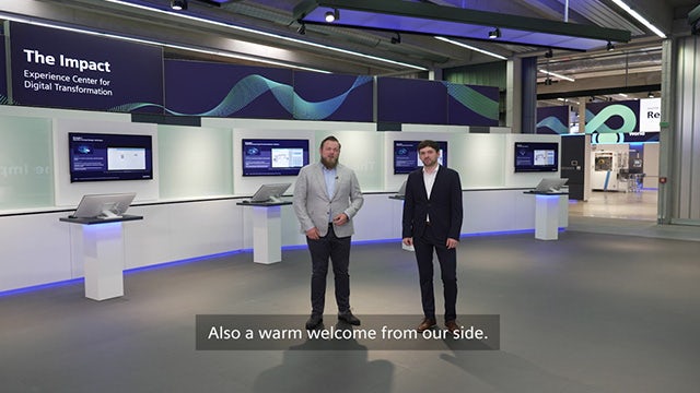 Two men in the Siemens setting for "The Impact: Experience Center for Digital Transformation."