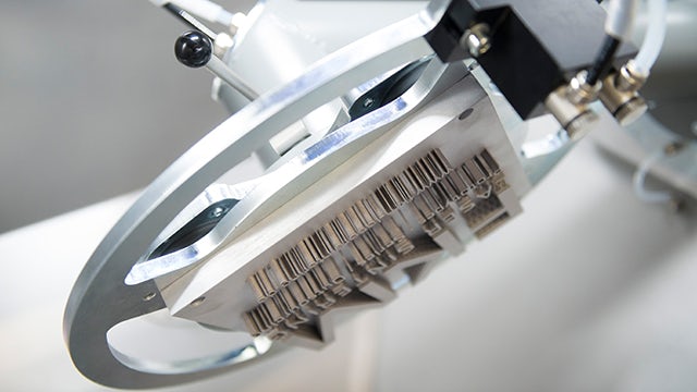 A group of people in a factory setting, wearing protective gear and working on cleaning equipment.