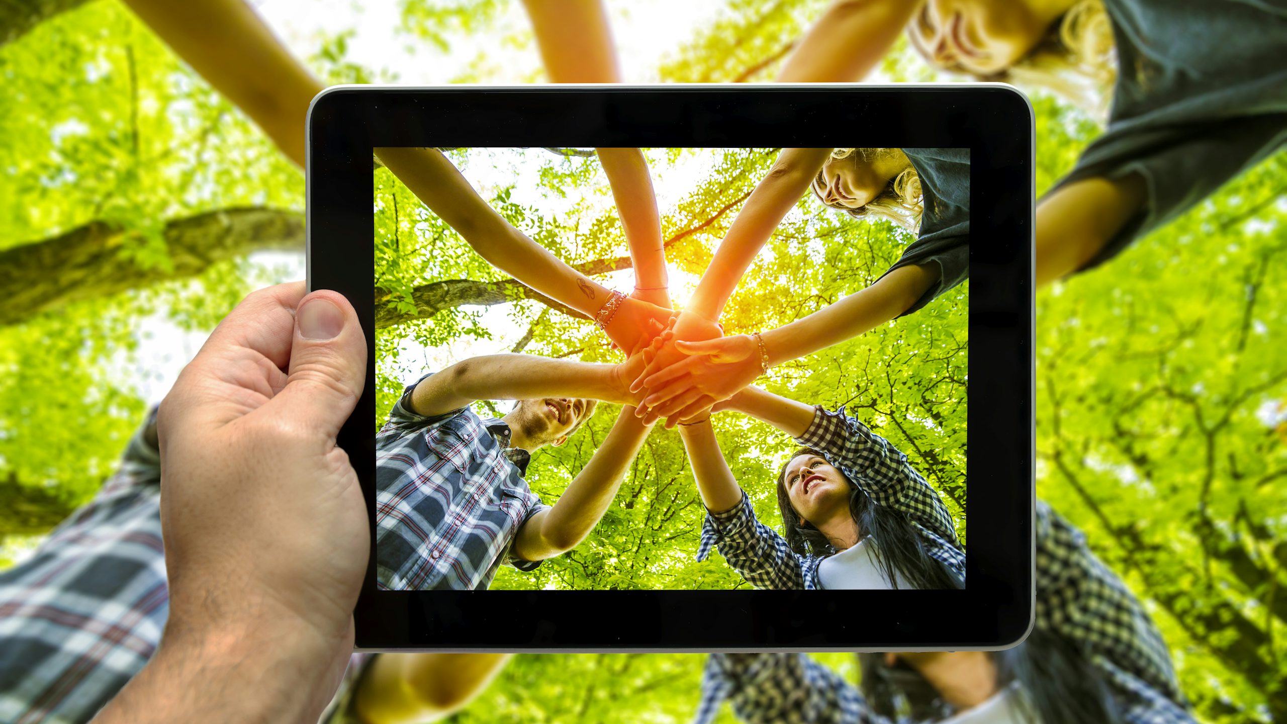 A person holds a sign about equalizing opportunities in front of a diverse crowd.