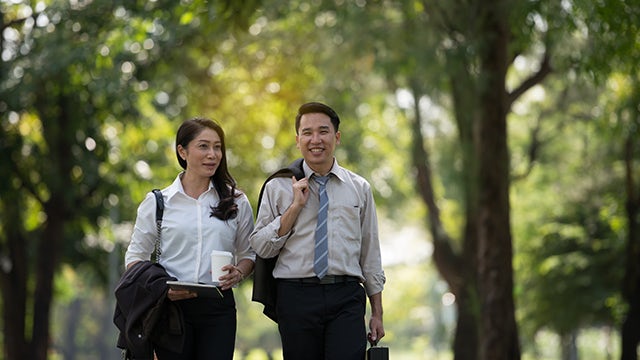 Colleagues walking in a park.