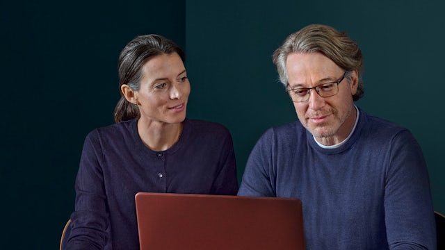 A poster with a man and a woman standing in front of a building with a safety sign on it.